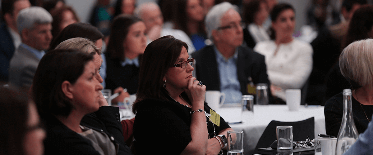 three women watching speaker